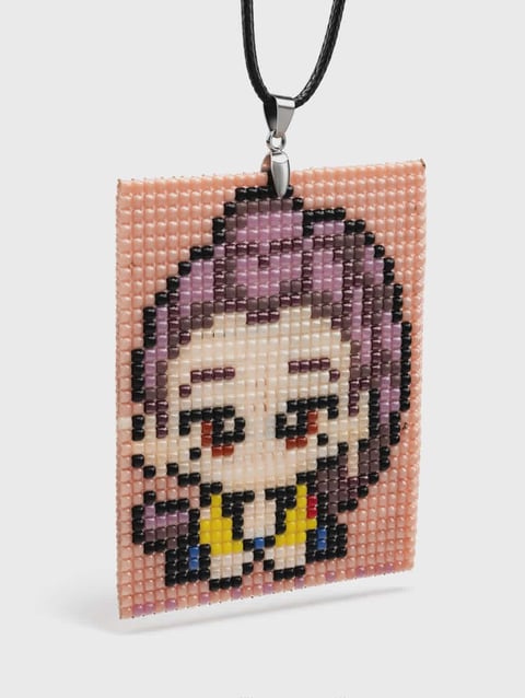 Pixelated beaded pendant featuring a smiling cartoon character with purple hair and yellow collar on coral background