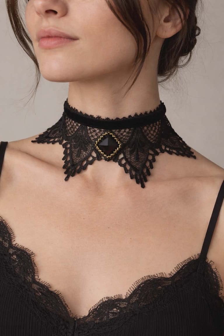 Woman wearing a black lace choker necklace with intricate mesh detailing and geometric center accent